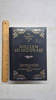 Front cover of The Complete Works of William Shakespeare hardcover book with ruler for scale.
