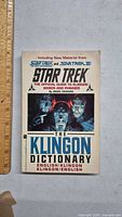Front cover of The Klingon Dictionary book showing title, author, and Star Trek characters.