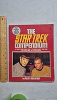 Front red cover of The Star Trek Compendium book with Spock and Captain Kirk images