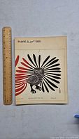 Front cover of the 'Inunnit' 1968 art book showing a stylized bird illustration in black and red and a wooden ruler for scale.