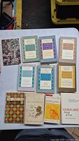 Photo of 11 vintage Søren Kierkegaard-related books spread on a table, showing cover titles and various colors.