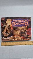 Front cover of the book 'Yesterday's Toronto 1870-1910' with a ruler placed below for scale.