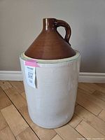 Photo showing full view of the 6-gallon crock jug, highlighting the two-toned brown glazed top with handle and lighter base.