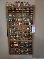 Full view of wooden letterpress tray filled with small toy cars and collectibles