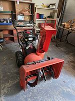 Front-left three-quarter view showing model decal, auger housing, chute and handlebar