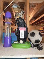 All three lamps together on shelf: purple Kenart Enterprise tornado lamp, golfbag lamp with golf clubs and ball, soccer ball jelly lamp
