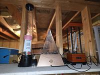Top view showing three items: a tall cylindrical aquarium lamp, a pyramid aquarium lamp, and a wooden framed electric wind chime.