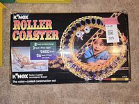 Box front showing the KNEX Roller Coaster set, 2400 pieces, 8 feet long, 3 feet high, 26 feet of track, color-coded construction set branding.