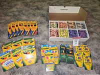 Full assortment of Crayola crayons, markers, colored pencils, and large box of assorted crayons laid out on carpet.