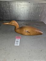 Full side view of the wooden loon decoy showing smooth wood finish and bird profile