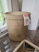 Full view of the beige ceramic Imperial Medalta crock with metal handles, showing size and shape.