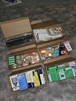 Six boxes of school supplies including rulers, tape rolls, glue sticks, stickers, highlighters, and markers all brand new.