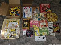 Wide view of all educational resources spread on floor with cardboard boxes and trays containing items including wooden shapes and flash cards.