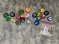 Top-down photo showing all 19 vintage yo-yos and a sealed bag of extra string on carpeted floor.