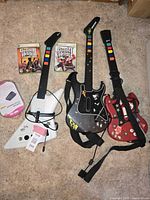 Overview of all three Guitar Hero guitar controllers and two game cases plus USB wireless receiver