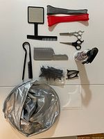 Complete hair cutting kit with combs, scissors, clips, mirror, spray bottle, and cape laid out on a white surface