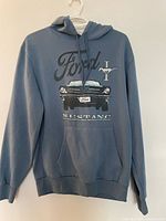 Full frontal view of the blue men's hoodie showing large front graphic of Ford Mustang car and text.
