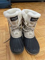 Front view of Storm by Couer winter boot showing black rubber lower, beige upper and fleece interior