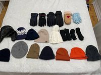 Top-down view of all included winter hats and gloves on a white surface showing different styles and colors