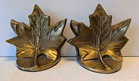 Front view of both brass maple leaf bookends