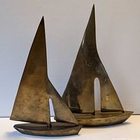 Two brass sailboat sculptures, size comparison