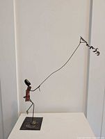 Full view of metal figure sculpture on base