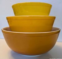 Front view of three nested Pyrex bowls showing color gradation and white interiors