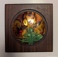 front view of wood plaque showing circular enamel floral insert