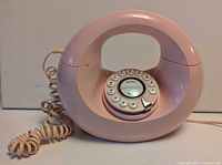 front view of pink oval touch-tone phone with coiled cord