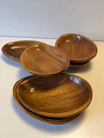 Six wooden oval dishes stacked and fanned