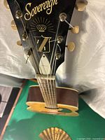 Angled view of headstock and upper neck showing Harmony Sovereign logo and six tuning machines