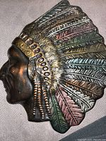 Side profile of the Indigenous chief wall art bust showing detailed feather headdress and facial features.