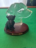 Front view of the Bradford Exchange figurine showing the black Labrador dog seated in front of the frosted Labrador head silhouette on a wooden base with brass plaque.