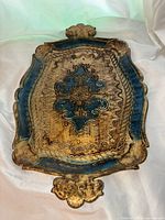 Full view of the vintage Italian Florentine wooden serving tray showing the ornate central motif, blue and gold gilt finish, and decorative edges with handles.