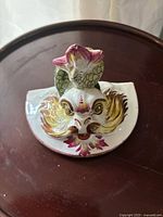 Top-down image showing the front fish head spout design of the ceramic wall fountain basin with hand-painted details.