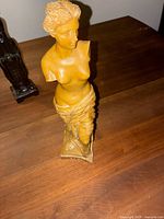 Front and side views of the yellow ceramic/plaster vintage A. Santini Venus de Milo sculpture with signature on base.