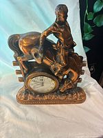 Front view of vintage antique Sessions clock showing cowboy on bucking bronco with clock face at the base.