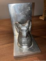 Full view of the antique/vintage metal ram head bookend showing the flat back and base and detailed ram head at the front.