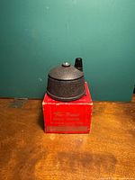 Pencil pointer tool on top of original red box, showing tool details and box branding.