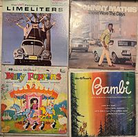Four vintage vinyl record albums including The Limeliters, Johnny Mathis, Mary Poppins soundtrack, and Bambi soundtrack.