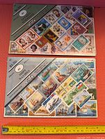 Two vintage collectible stamp packs: one features 40 music composers; the other 40 sailing ships. Each pack in original sealed packaging with clear front showing colorful stamps.