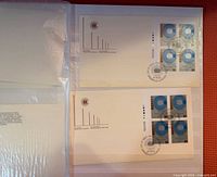 Photo showing two blocks of four Canadian stamps each with blue and white or blue and black globe designs, postmarked with official cancellation marks.