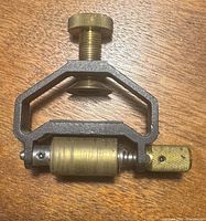 Top view of the honing guide showing the brass adjustment knob and roller with a cast metal frame.