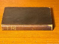 Closed vintage book with dark brown leather spine and gold embossed title