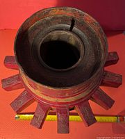 Top view of the red wooden wagon wheel hub showing the hollow center and ten spokes extending outward.