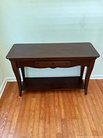 Front view of the dark brown wood console table showing drawer and lower shelf