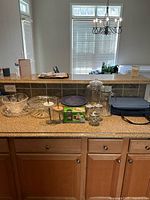 Wide shot of all glass serving pieces and storage container displayed on kitchen counter