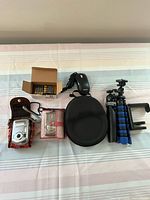 Full view of all items including cameras, headphones, tripods, charger, case, and batteries.