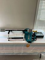 A photo showing all workout items spread on a table including pull-up bar, weighted vest, dumbbell, wrist weights, and black box.