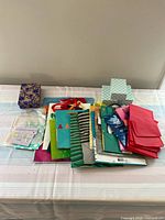 Overview of gift bags, wrapping paper, gift tags, and tissue paper set spread on folded tablecloth.